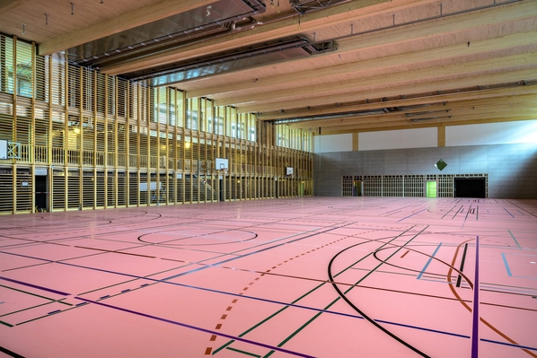 Die untenliegende 3-fach Turnhalle mit den überspannten Holzträgern (Länge: 35 m)